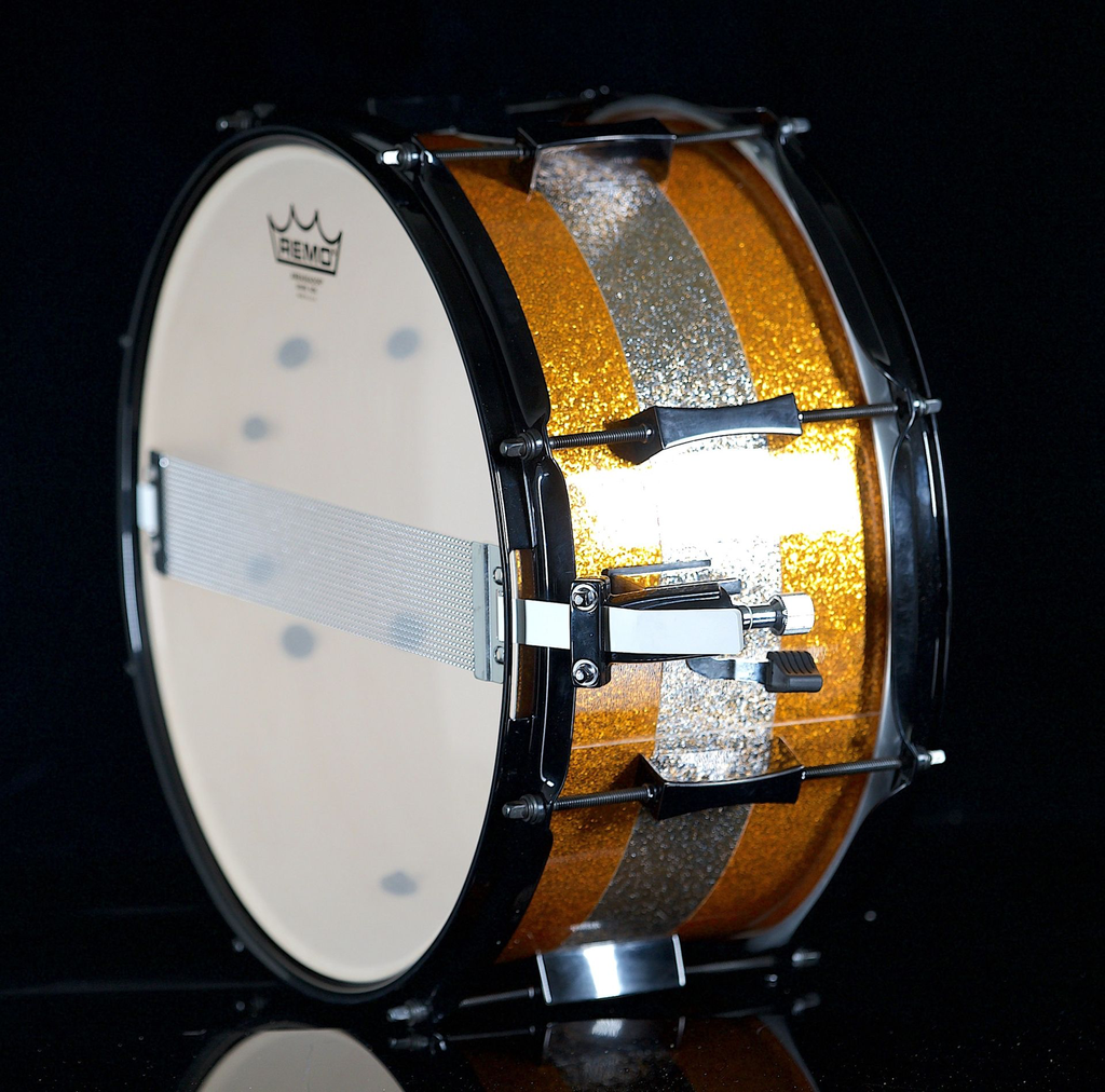 PORK_PIE_PERCUSSION_7_X_13_SNARE_DRUM_IN_ORANGE_SPARKLE_AND_CHAMPAGNE_SPARKLE_STRIPE_W_BLACK_HARDWARE-68d1ffbad59bc.webp